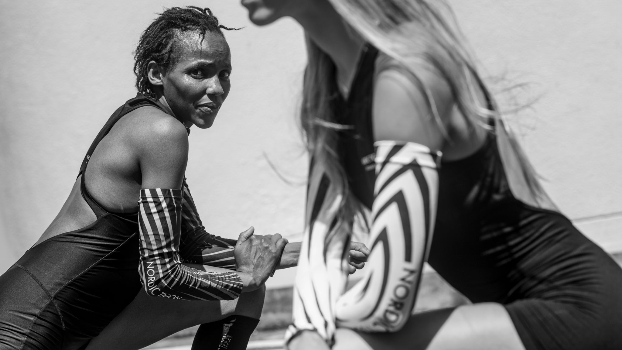 Two Nordic Tigon runners stretching together